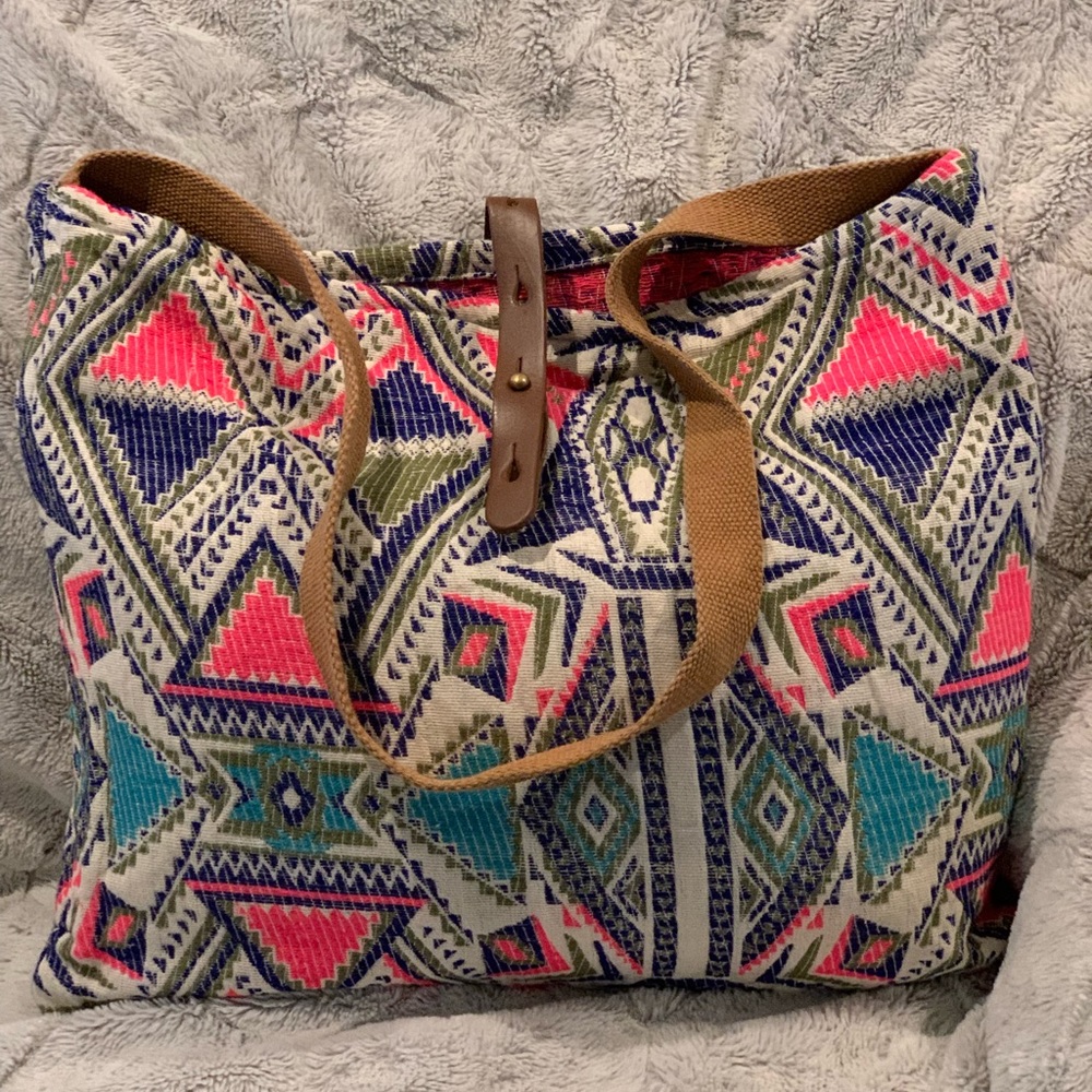 Lovestitch large tote. 1 inside drop pocket. Leather strap and button closure